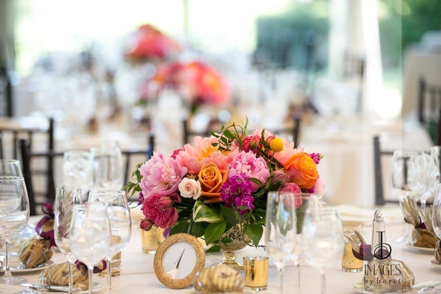 A vibrant wedding tablescape, adorned with colorful flowers and elegant gold utensils.