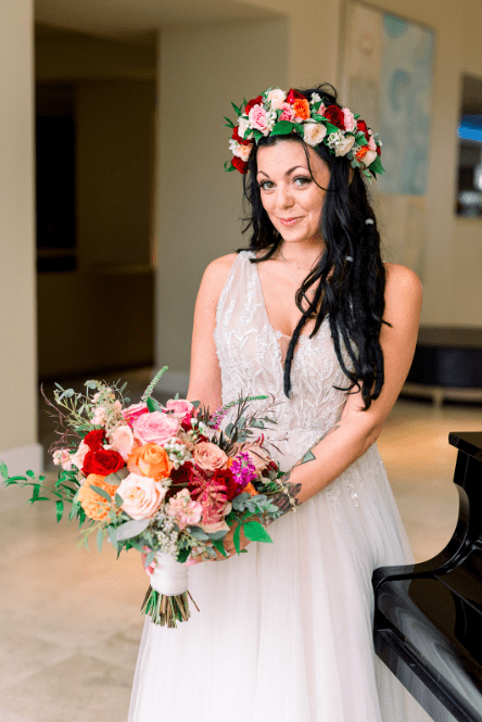A bride holding a bouquet in front of a piano.