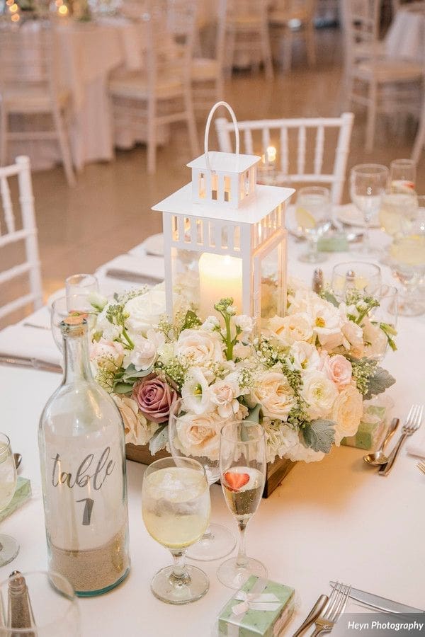 A table setting with a lantern and white flowers.