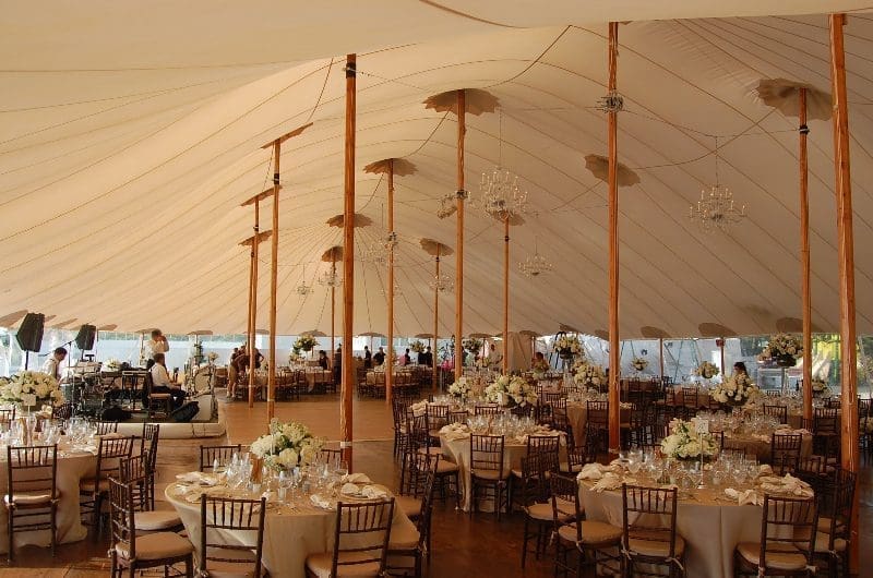 A large tent with tables and chairs in it.