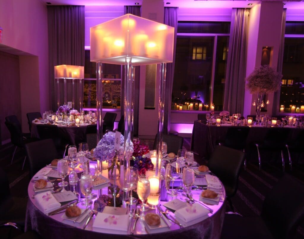 A table set up with purple lighting at a wedding reception.