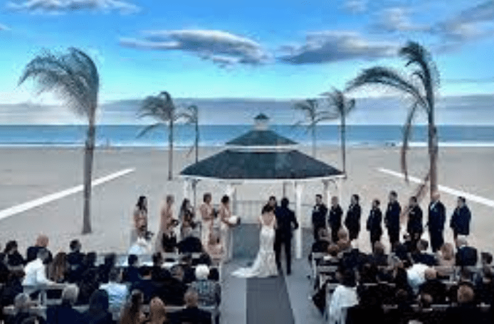 A wedding ceremony on the beach with palm trees.