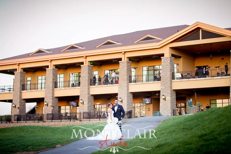 A bride and groom standing in front of a large building.