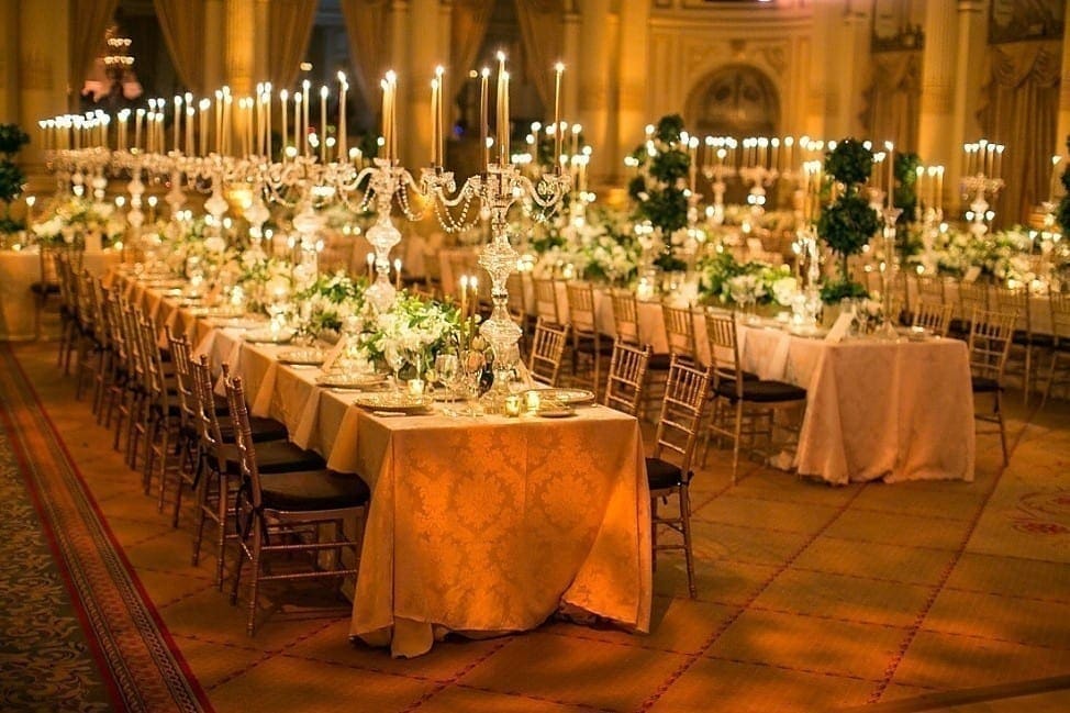 A large ballroom filled with tables and candles.