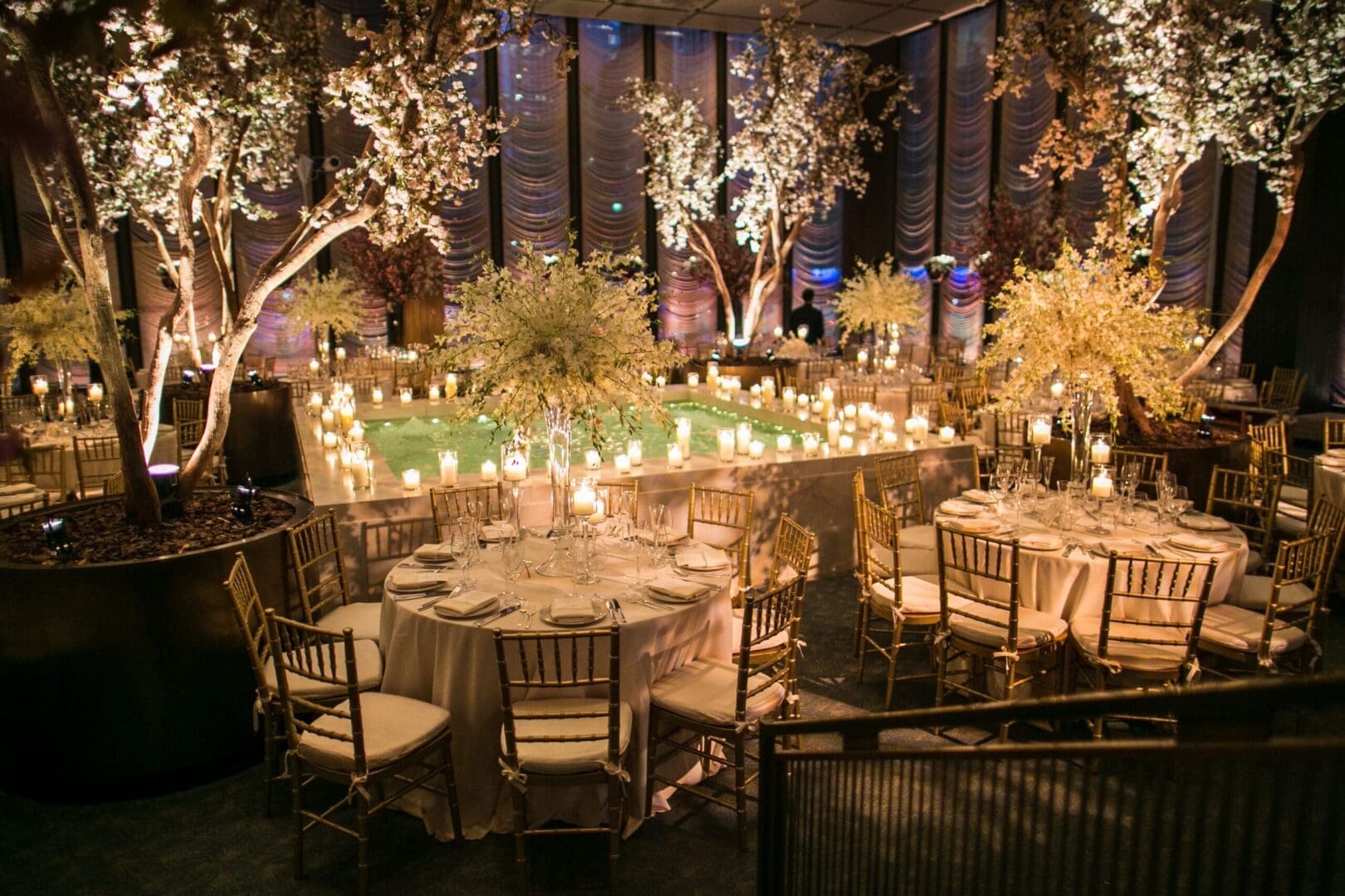 A wedding reception set up with tables and candles.