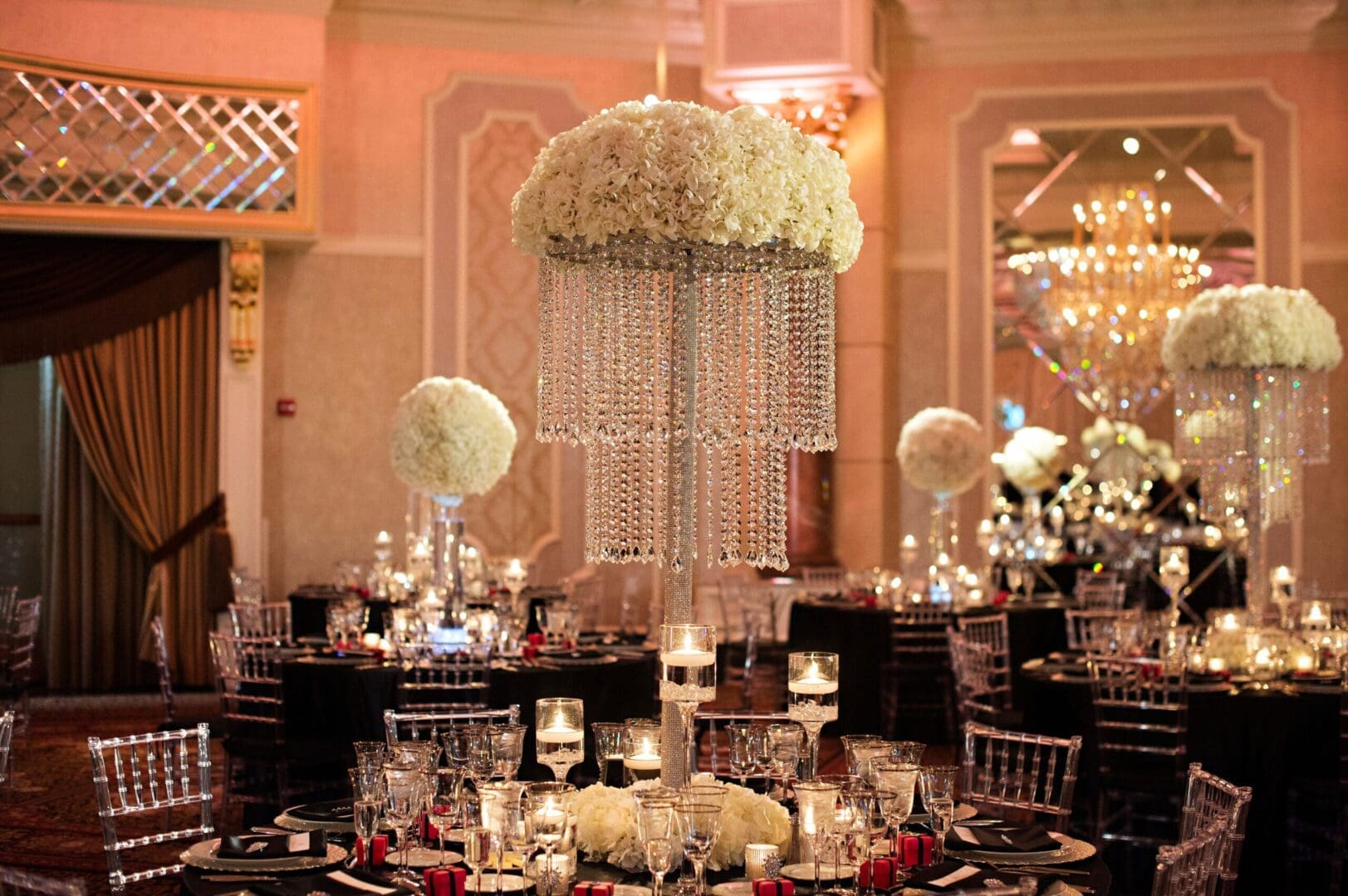 A black and white ballroom decorated with white flowers.