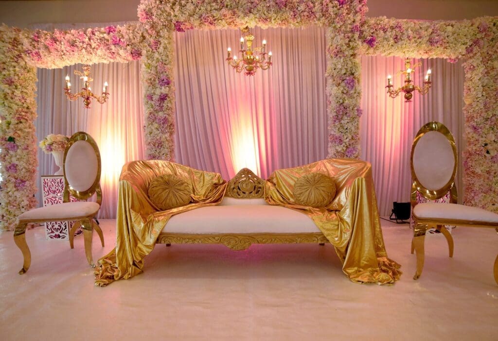 An indian wedding stage with gold and white decorations.