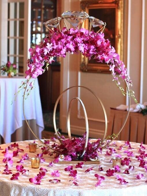 A wedding table decorated with orchids and a gold ring.