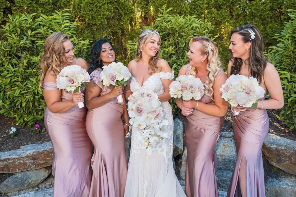 A bride and her bridesmaids pose for a photo.