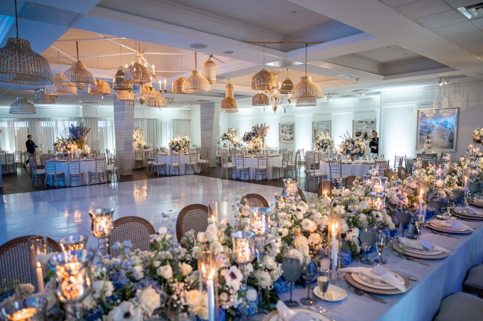 A wedding reception set up with white linens and candles, showcasing elegant wedding tablescape ideas.