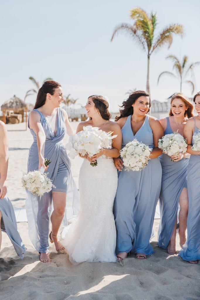 Bridesmaids in blue dresses on the beach.