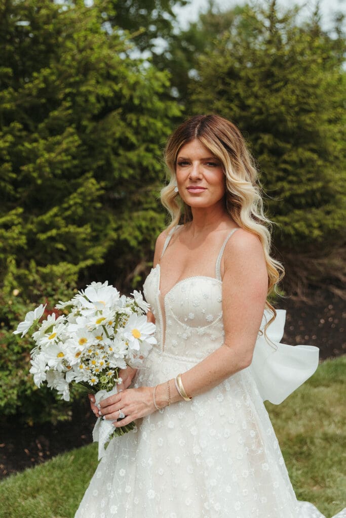 A bride in a white wedding dress holding a bouquet of flowers.