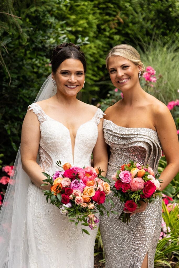 Two brides standing next to each other in a garden.