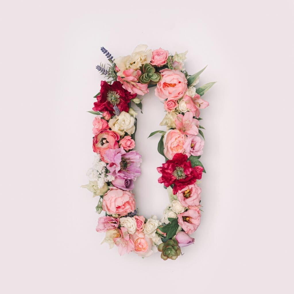 The letter o is made out of flowers on a white background.