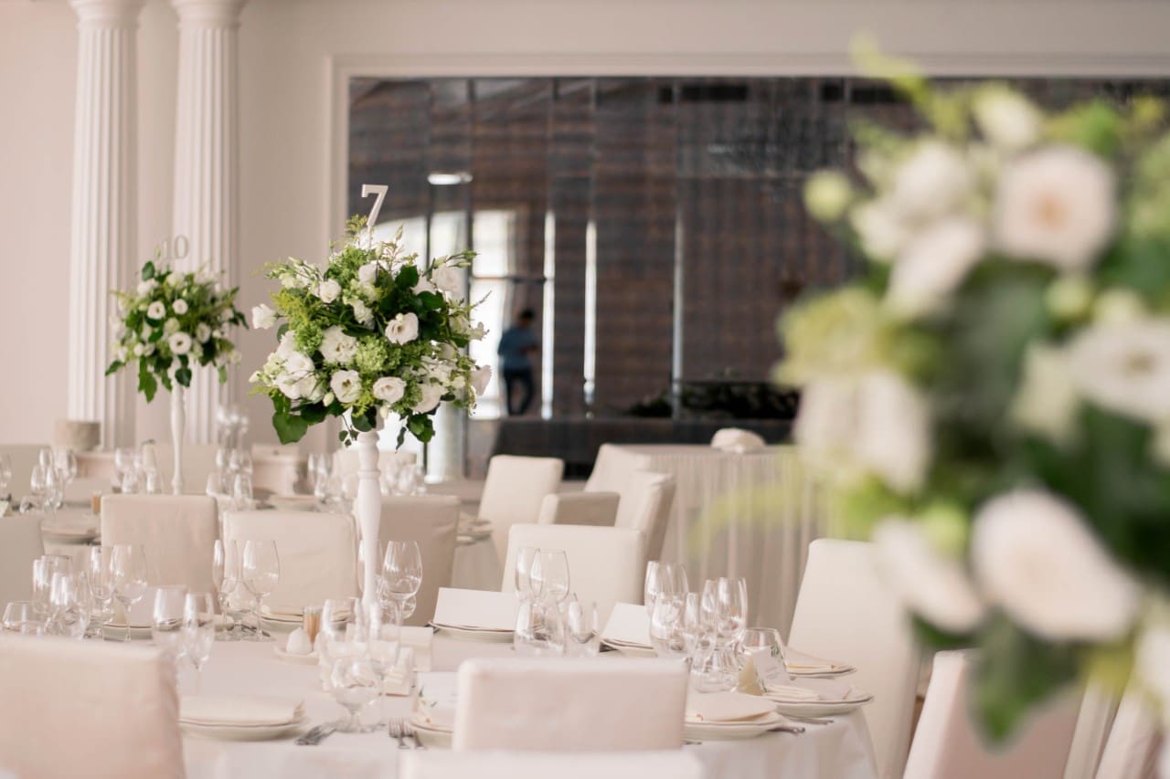 A wedding reception with white flowers and white tablecloths.