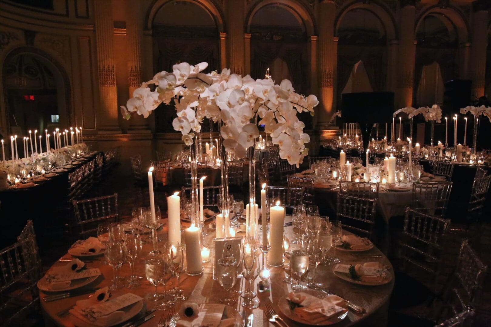 A stunning wedding table scape adorned with candles and orchids.
