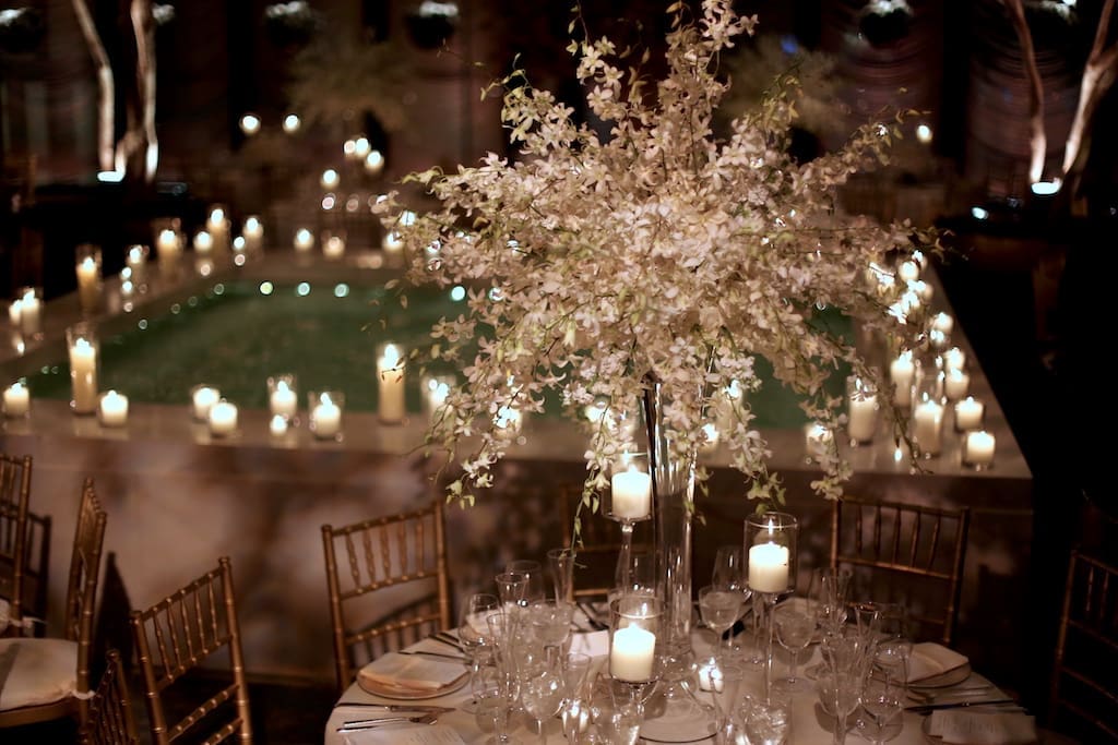 A captivating wedding tablescape with candles and flowers elegantly showcased in the center.