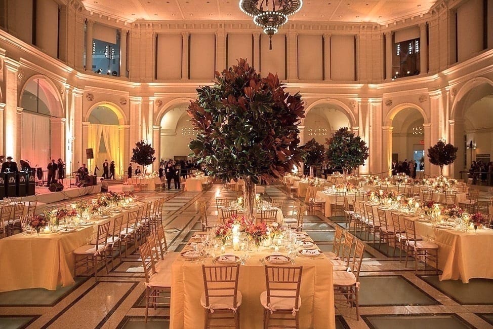 A spacious ballroom showcasing elegant tables and chairs arranged for a stunning wedding tablescape.