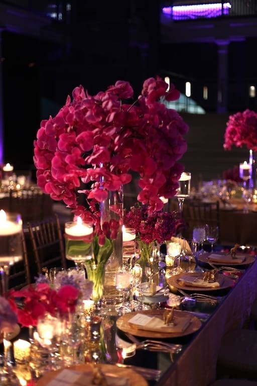 A beautifully decorated wedding table scape with pink flowers and candles.