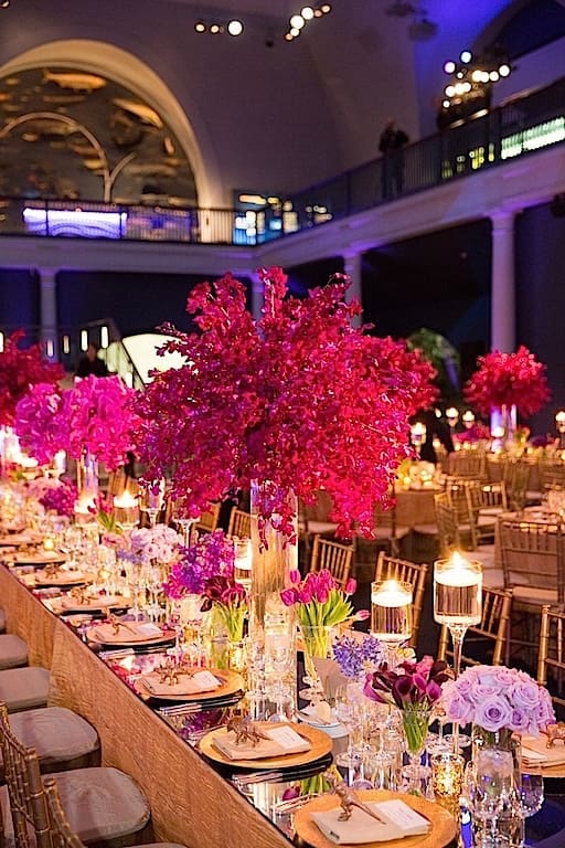 A gorgeous wedding tablescape adorned with purple flowers and candles.