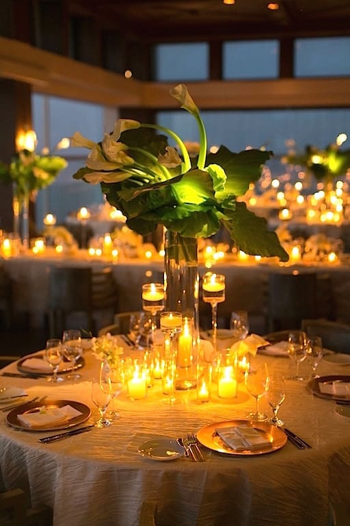 A wedding table is beautifully adorned with candles and flowers, creating a romantic tablescape.