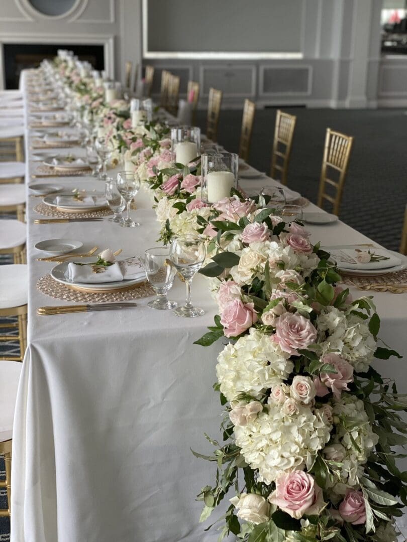 A stunning long table adorned with pink and white flowers, perfect for wedding tablescape ideas.