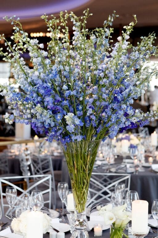Beautiful blue flowers in a vase on a wedding reception table.