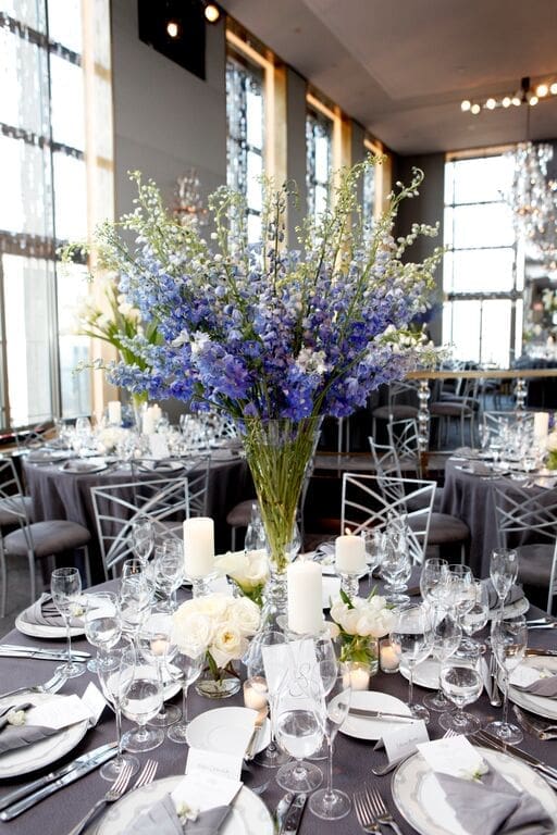 A stunning wedding tablescape adorned with blue flowers and silverware.