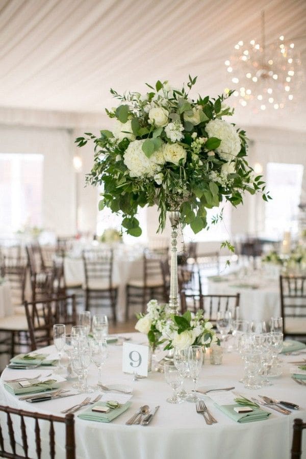 A stunning wedding tablescape featuring a white and green centerpiece.