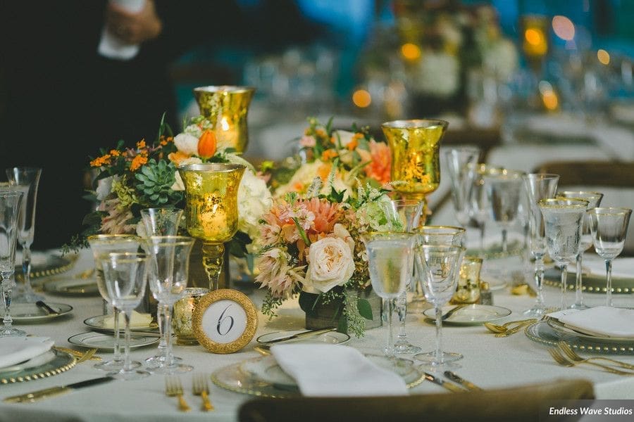 A stunning table scape featuring elegant gold vases and candles, perfect for wedding decoration ideas.