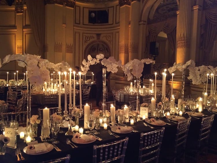 A stunning wedding tablescape adorned with black and white table setting, elegant candles, and beautiful flowers.