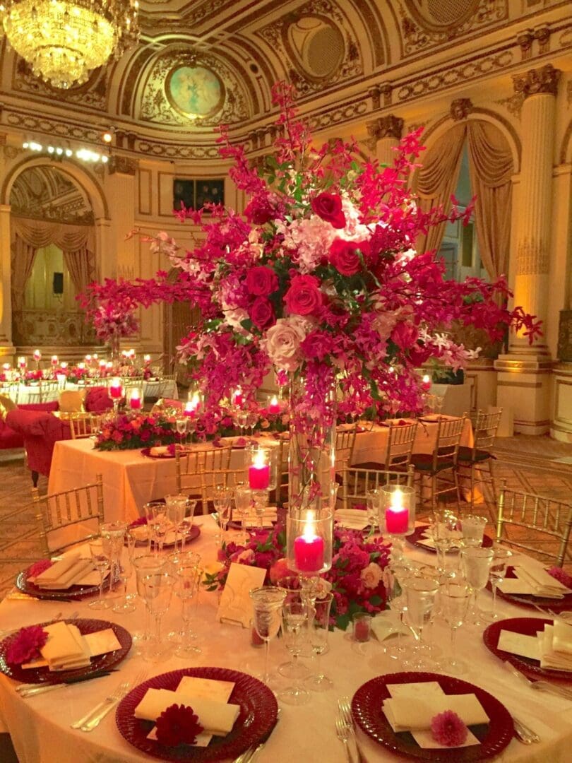 A beautifully arranged wedding table scape adorned with an elegant combination of red and pink flowers.