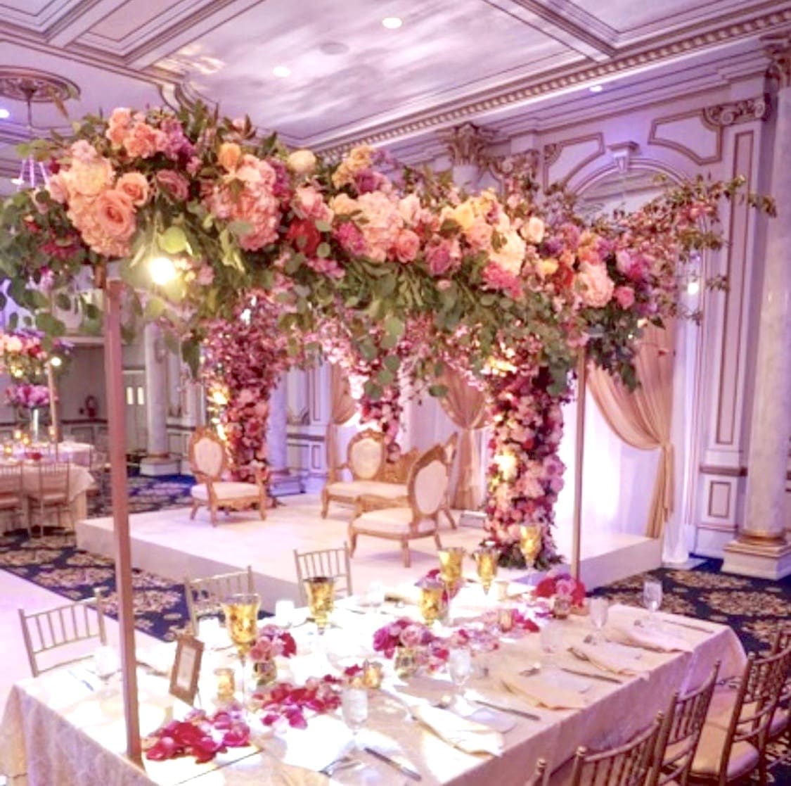 A wedding reception set up with a beautiful tablescape of pink and white flowers.