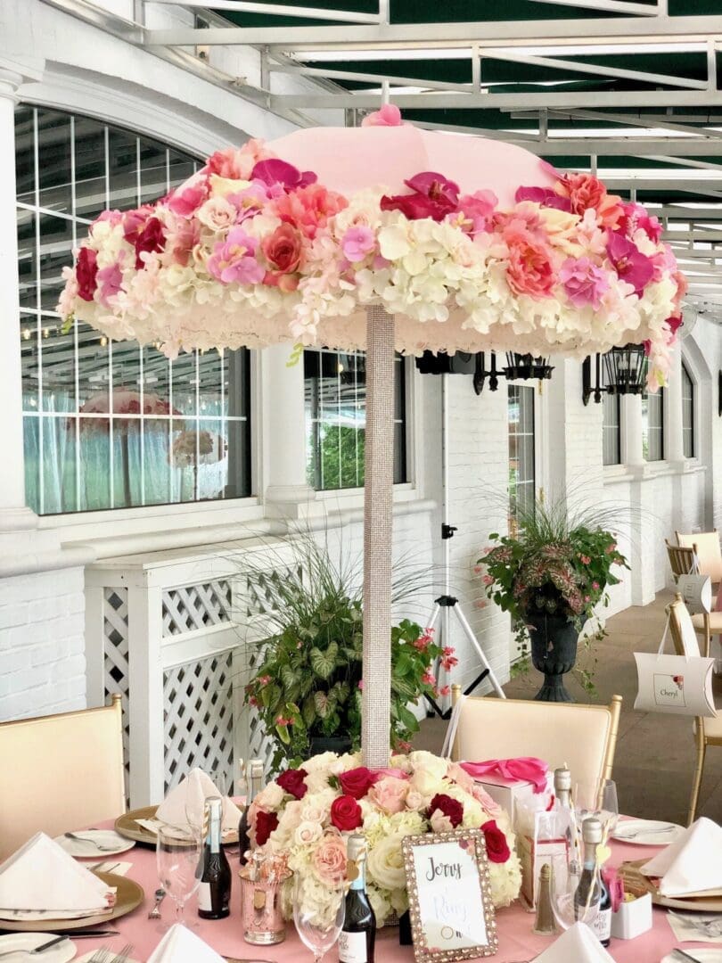 An elegant wedding tablescape with a pink and white color scheme, adorned with a charming umbrella.