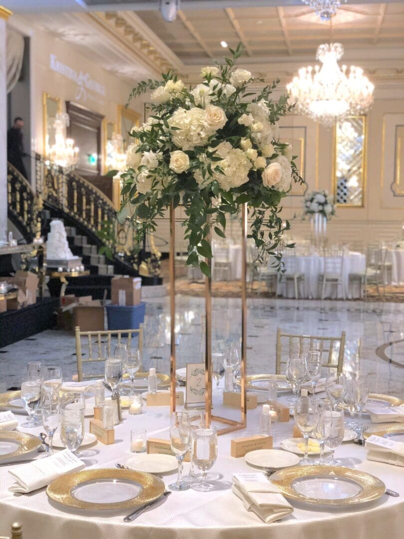 A wedding tablescape featuring a gold and white table setting adorned with elegant white flowers.