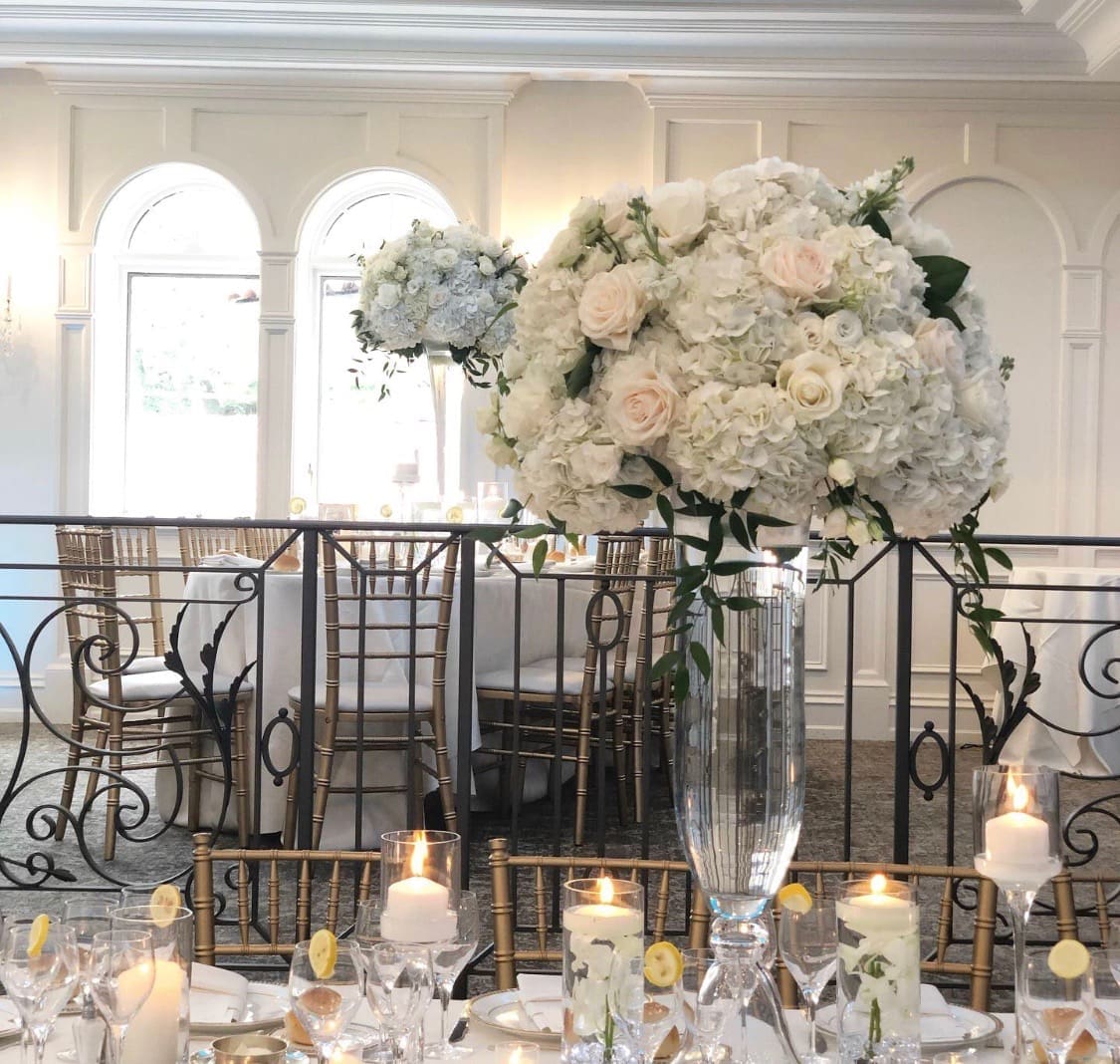 A romantic wedding reception with elegant white flowers and flickering candles, creating a stunning tablescape.
