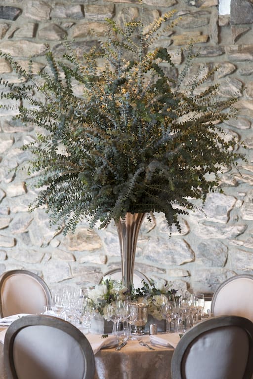 A wedding tablescape idea featuring a large plant in a vase.