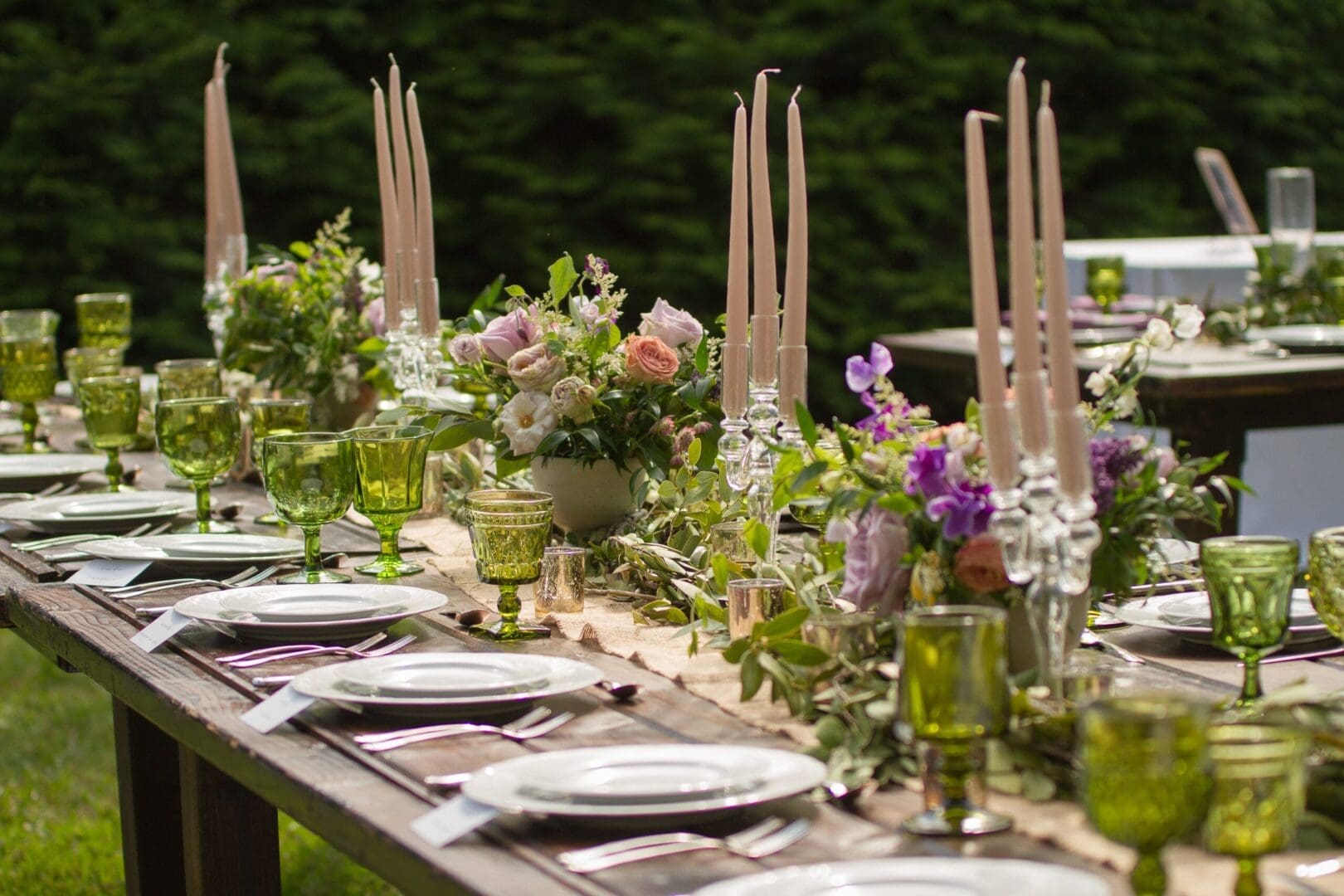 A stunning wedding tablescape adorned with green glasses and candles.