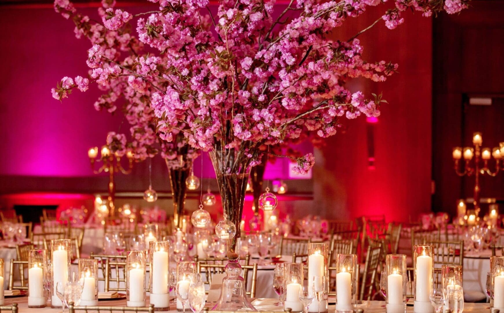 A wedding reception with pink flowers and candles, showcasing elegant wedding tablescape ideas.