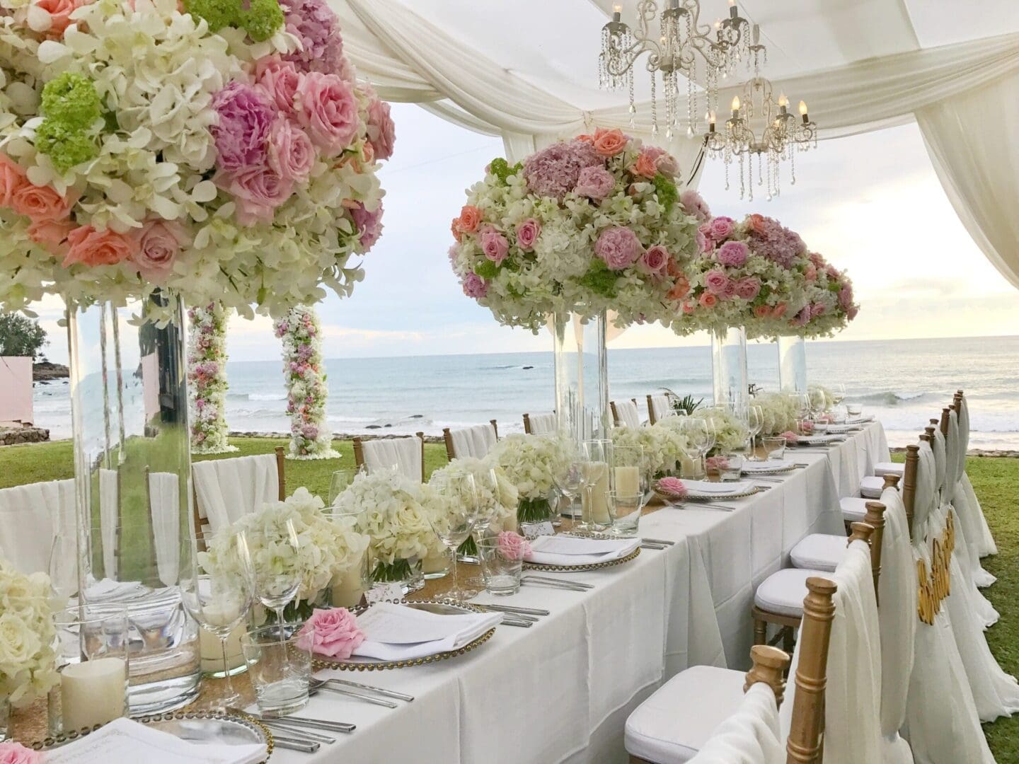 A wedding reception set up with white and pink flowers. Featuring elegant wedding table scape ideas.